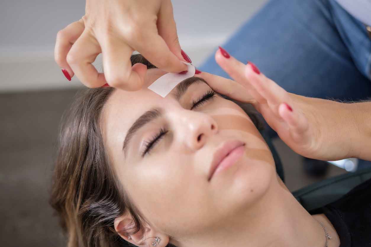 shot of a woman waxing her brows